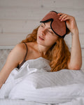 Signature Comfuurt Silk Sleep Mask - Woman waking up with sleep band