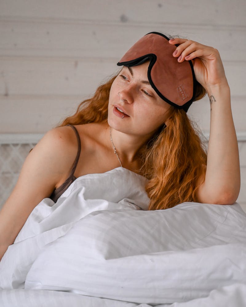 Signature Comfuurt Silk Sleep Mask - Woman waking up with sleep band